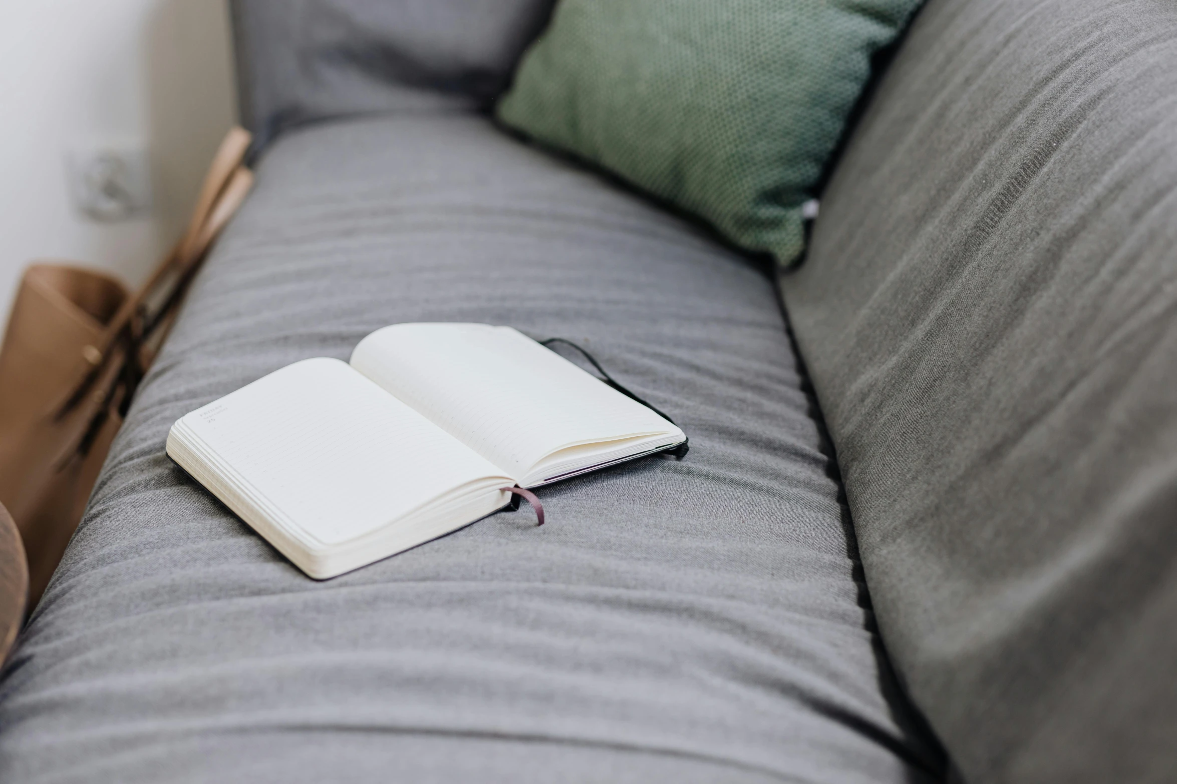 an open book laying on the arm of a sofa