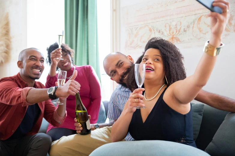 two woman and three men are drinking wine