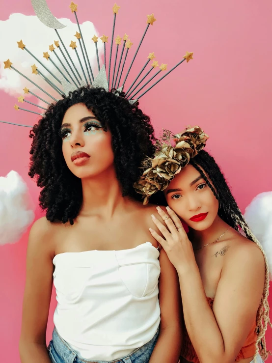 two girls pose in white top outfits with decorative headpieces