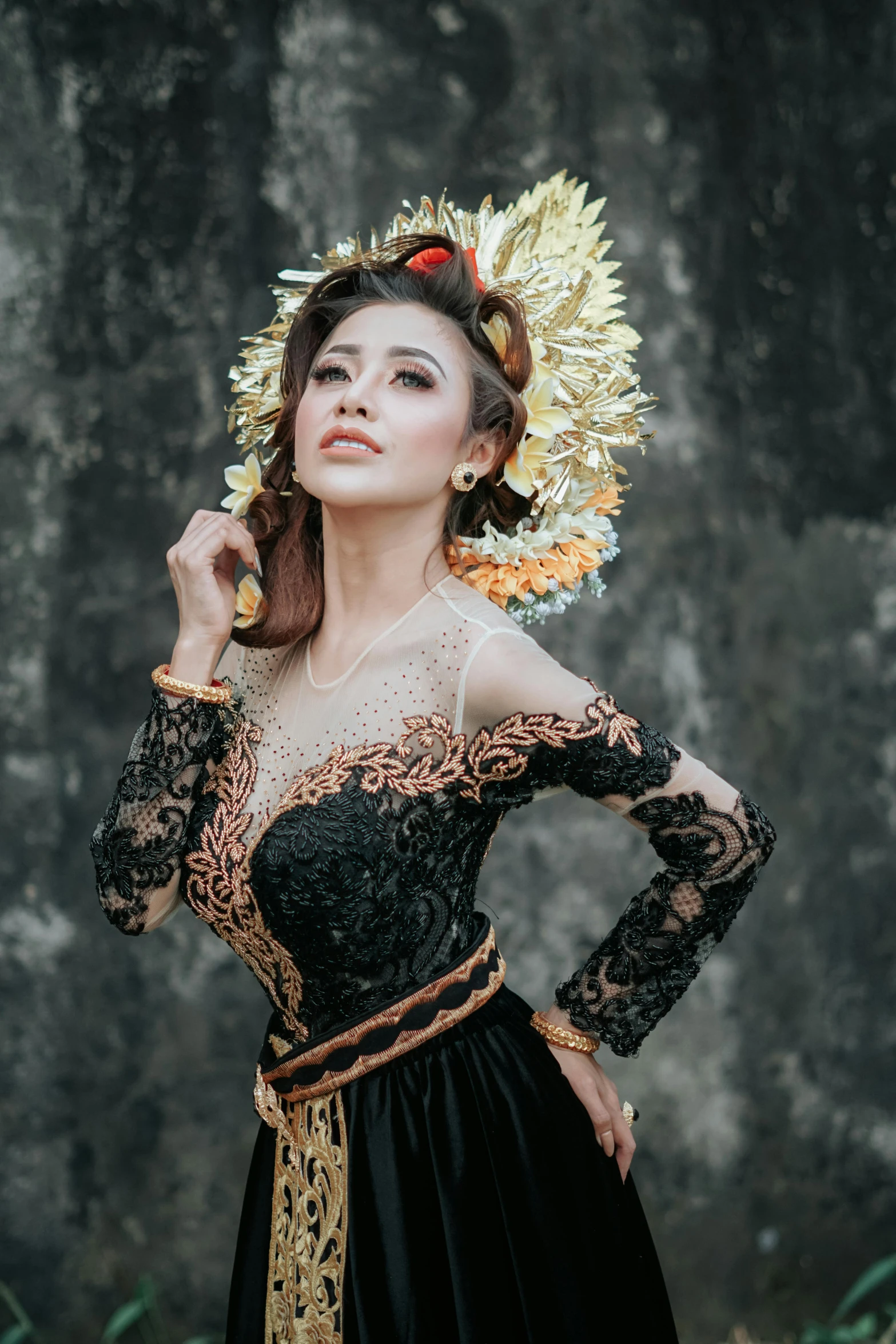 an oriental girl in a black dress and headdress is posing