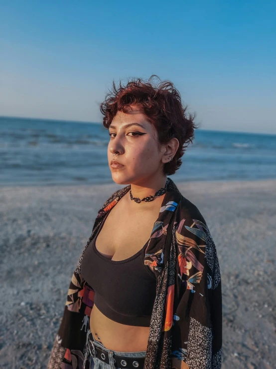 the woman stands at the water's edge near the sand and the ocean