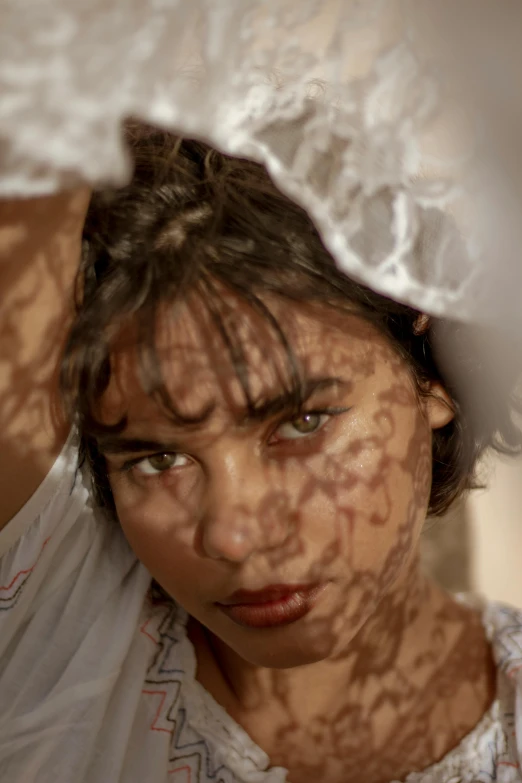 woman looking through curtain with hair on her head