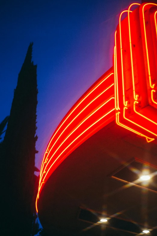 the neon red sign says the name of the motel