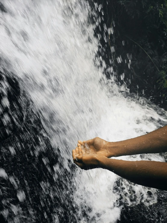 person with their feet up above the water falls