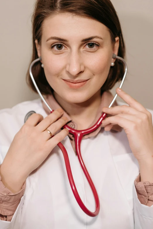 a smiling young woman holding onto a stethoscope