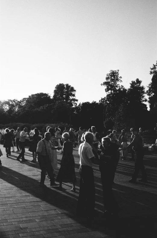 a crowd of people walking down the sidewalk