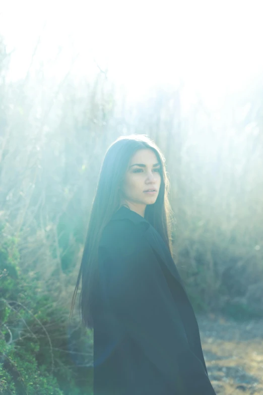 a woman stands on a path with trees in the background