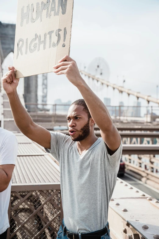 a man holding a sign over his head that reads human rights