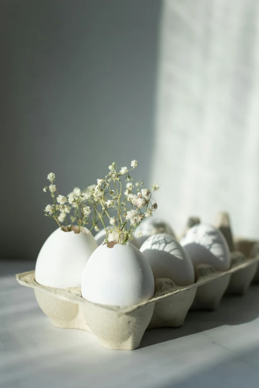 five eggs are in an egg cup with flowers in them