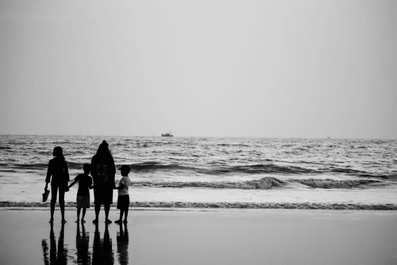 three people walking on the beach with a child