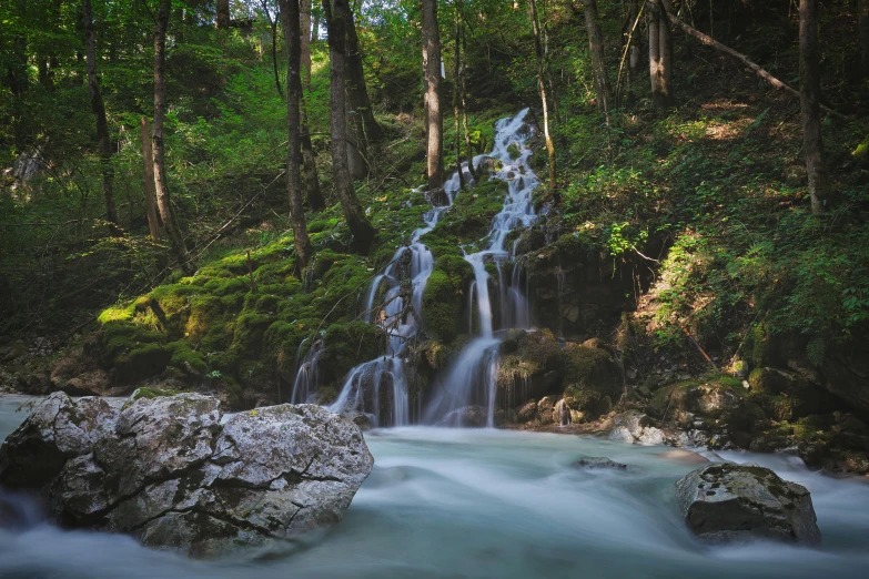 a waterfall is coming down a mossy slope