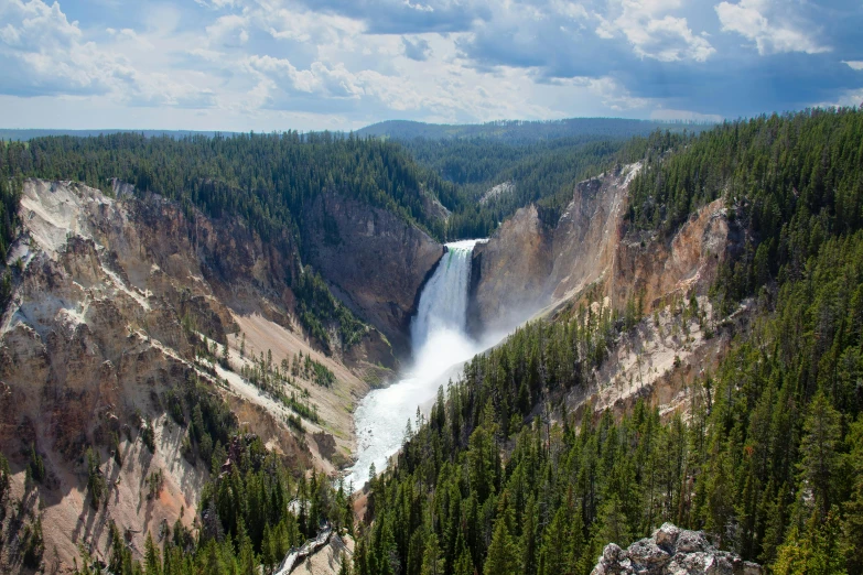 waterfall flowing into a gorge, with trees below