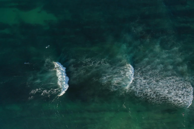 two wave crested above the water next to a small boat