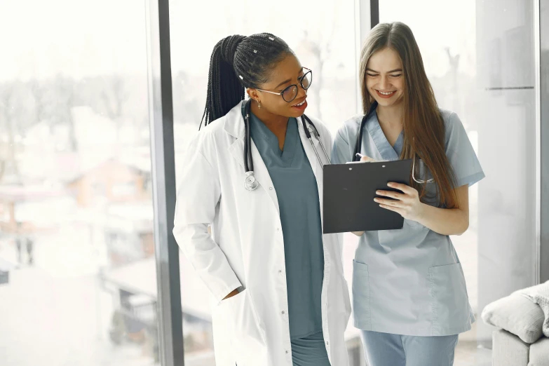 two nurse looking at the clip board of a patient