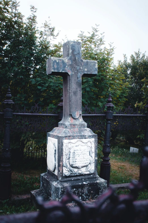 the old stone cross is situated at a cemetery