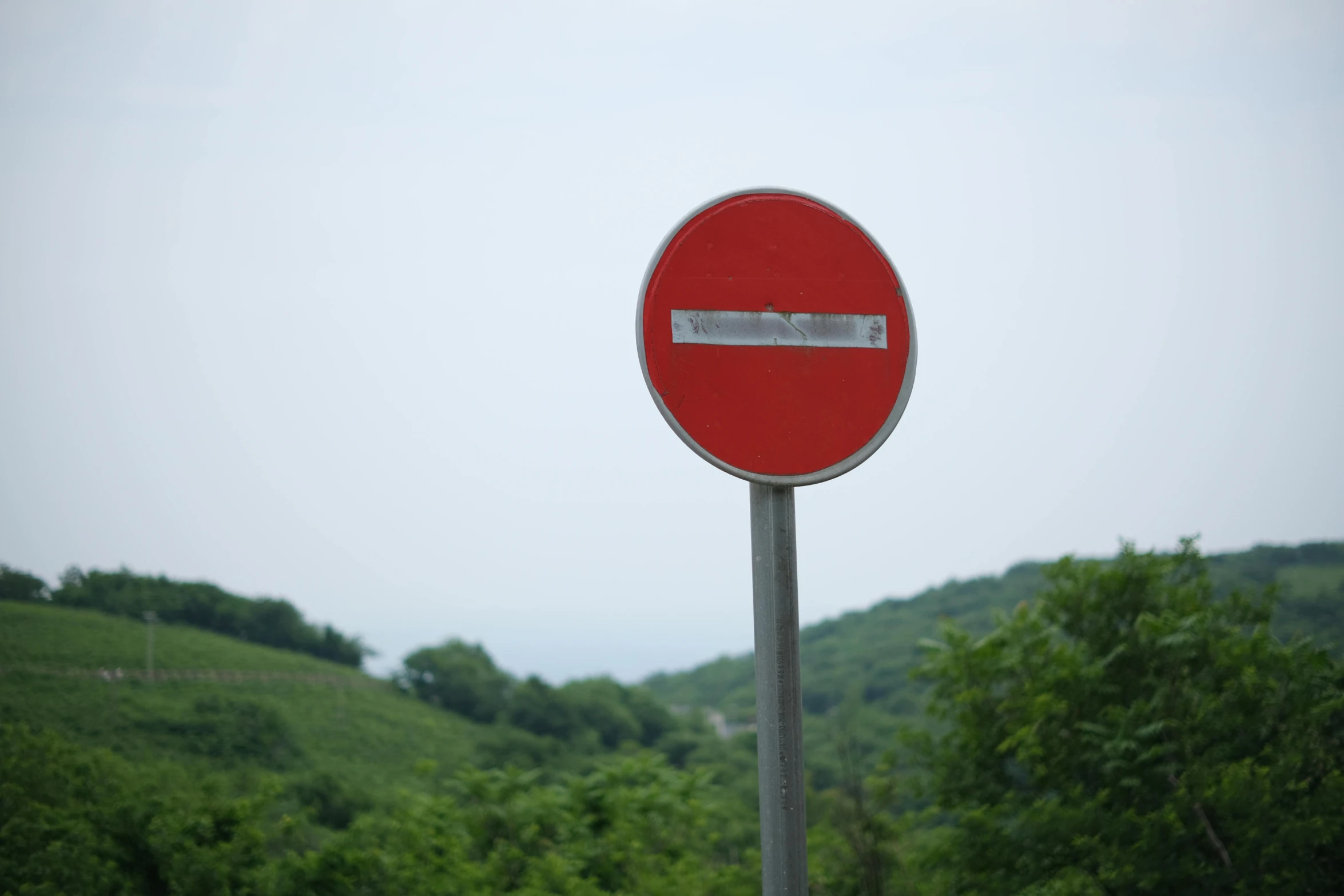 a red no entry sign in the mountains