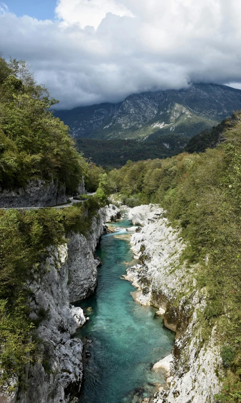 a narrow canyon filled with blue water below mountains