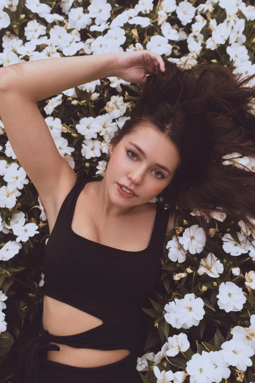 young beautiful woman relaxing on petals on the ground