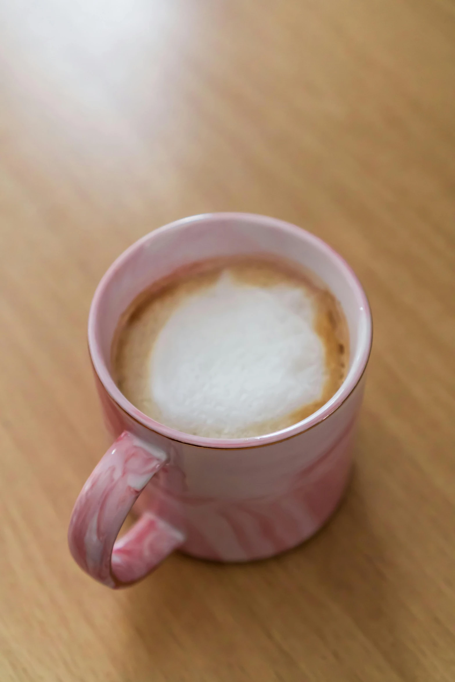 a coffee cup with a brown lid and pink handles