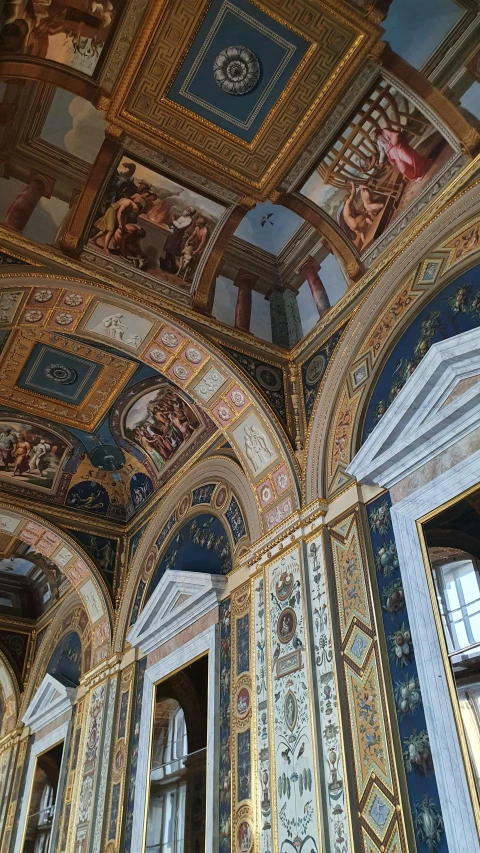 a wall painted with lots of colorful paintings and elaborately designed ceilings