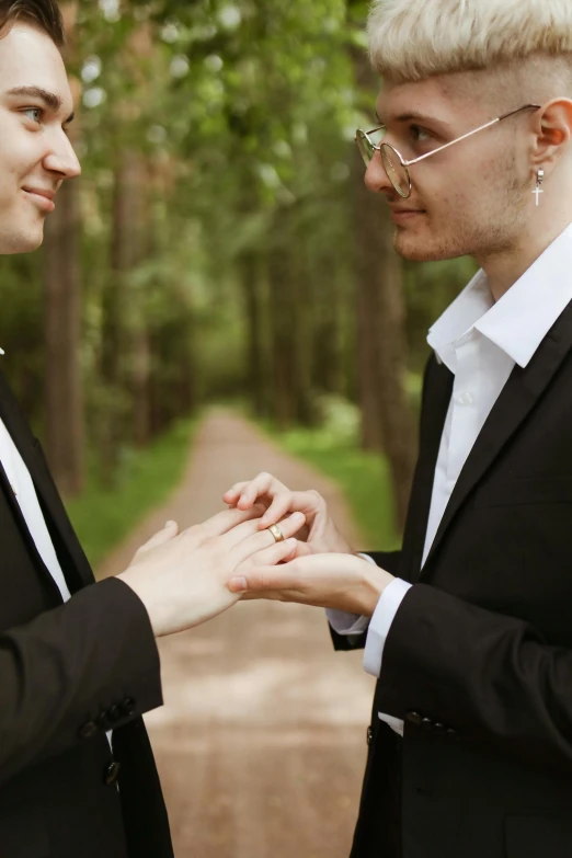 two men standing close to each other touching hands