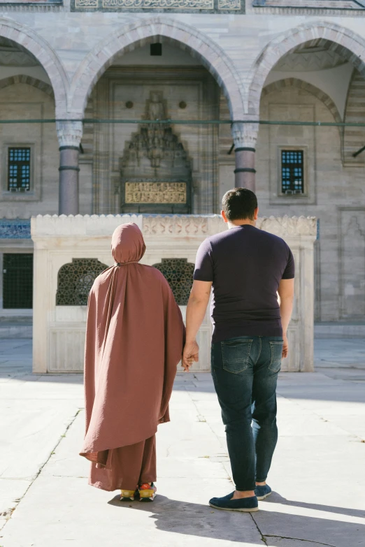 a man and woman are walking in front of a building