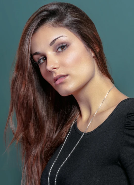 a woman is looking straight ahead with a chain on her neck