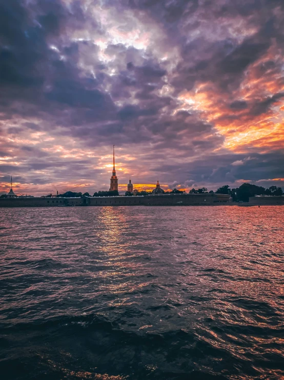 a church is seen from across the water during sunset