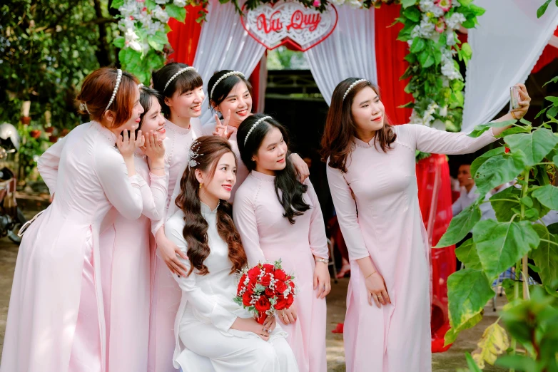 a group of young ladies dressed in pink dresses