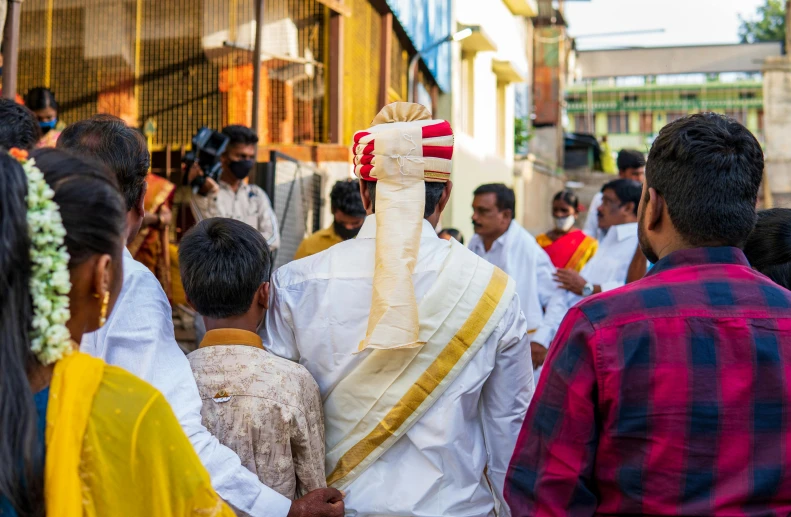 a priest walks with a group of people behind him