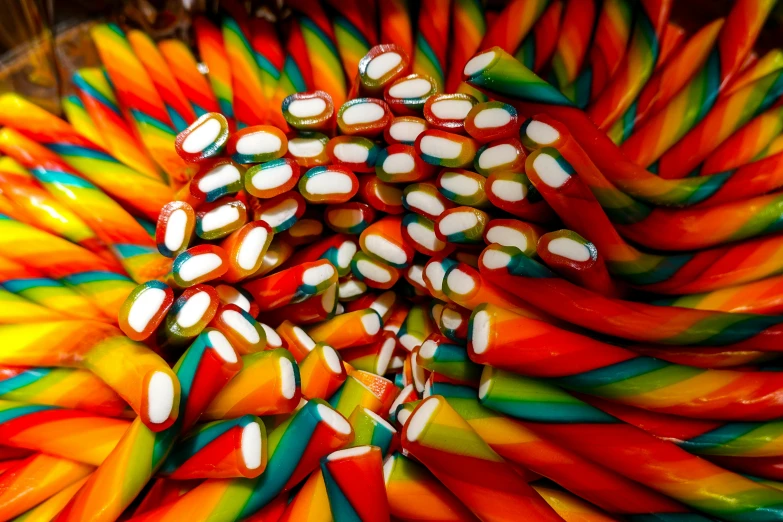 a brightly colored candy canes with white dots in a container