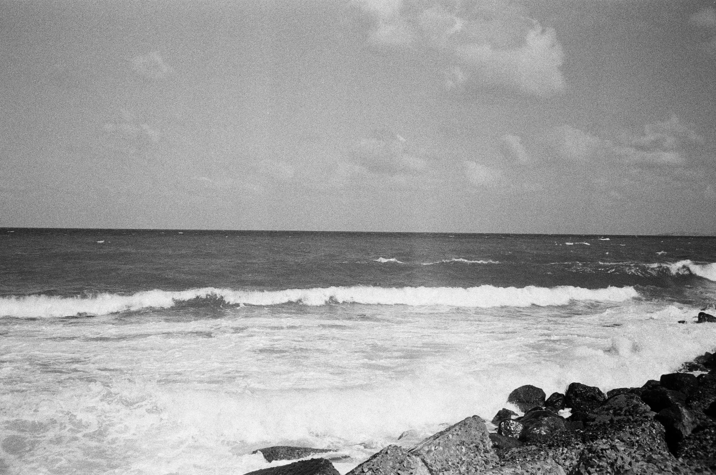 a person walking into the ocean with a surfboard