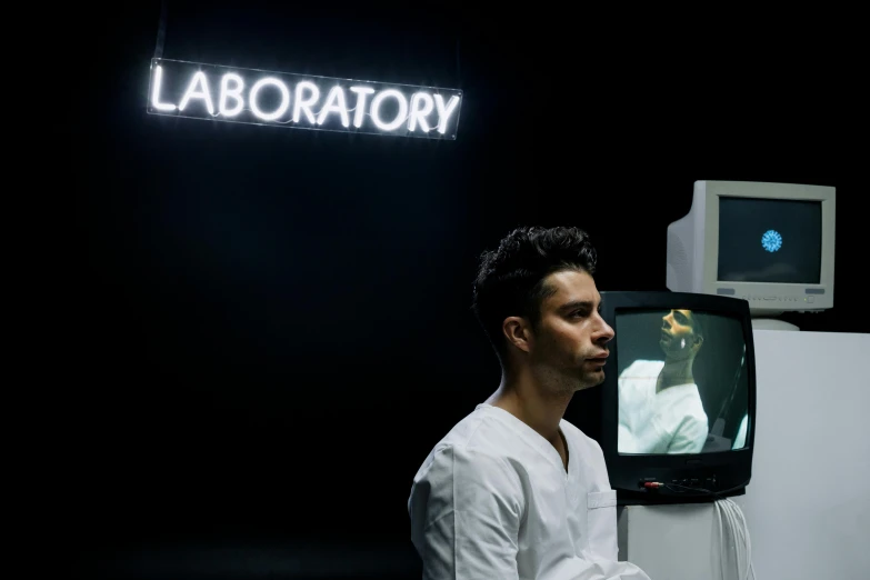 a man in white shirt in front of a tv