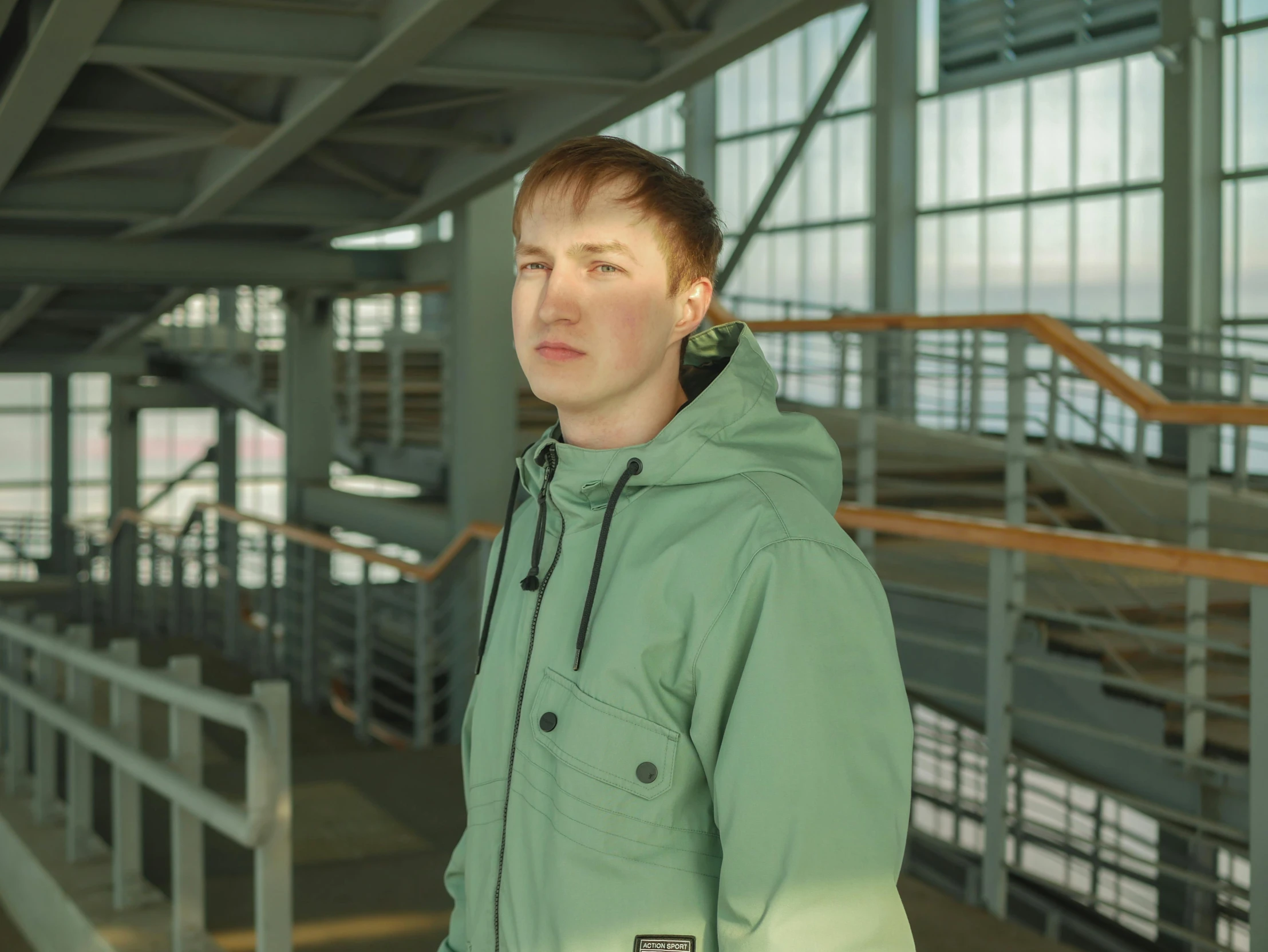 young man in green jacket posing for camera