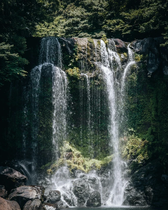 some white water falling over rocks near the trees