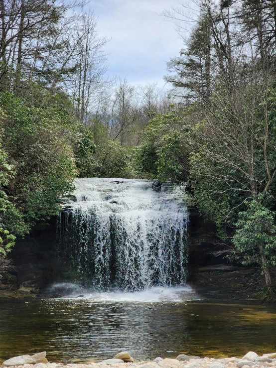 waterfall flowing over rocks in the middle of a stream