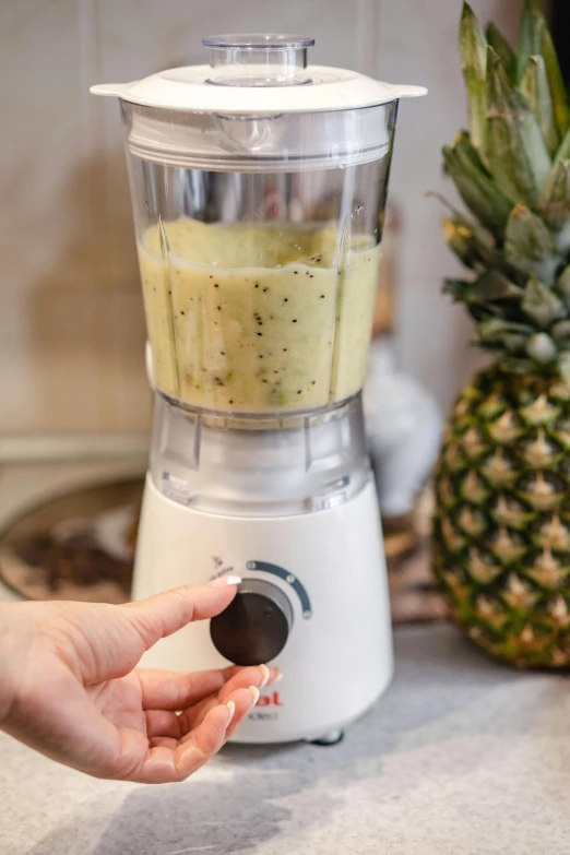 a person's hand in a blender on a counter