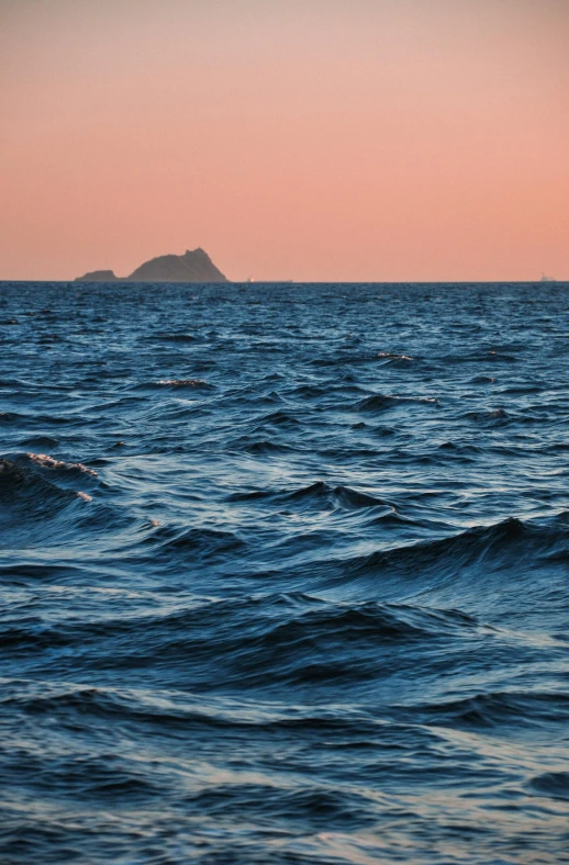 an island is in the distance on the water