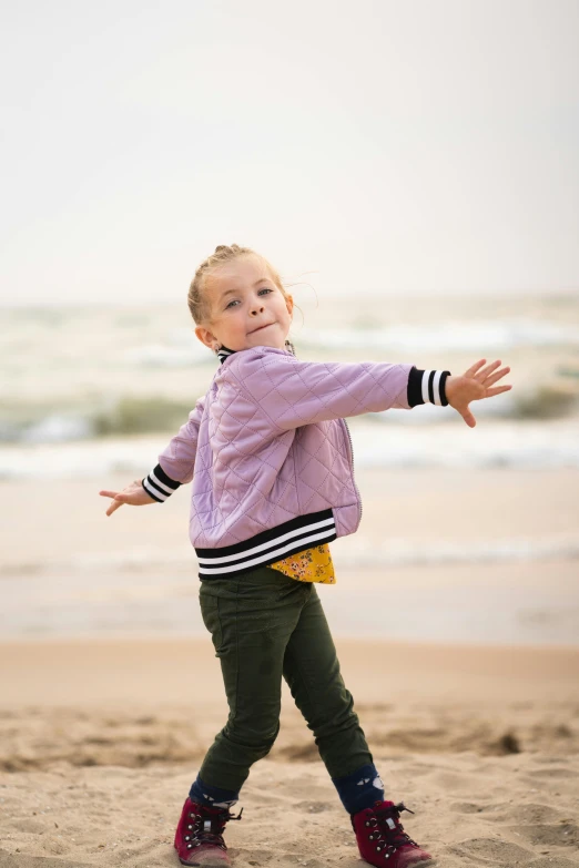 little girl walking across sand on the beach