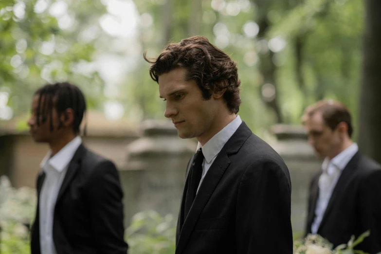 some men standing in front of trees wearing suits