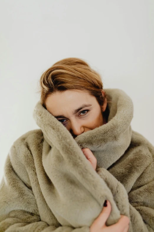 a woman wrapped in blankets smiles while looking