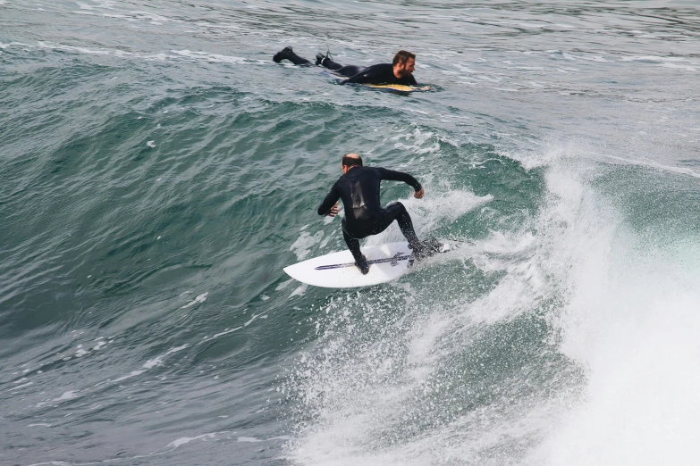 two surfers surfing and catching some very strong waves