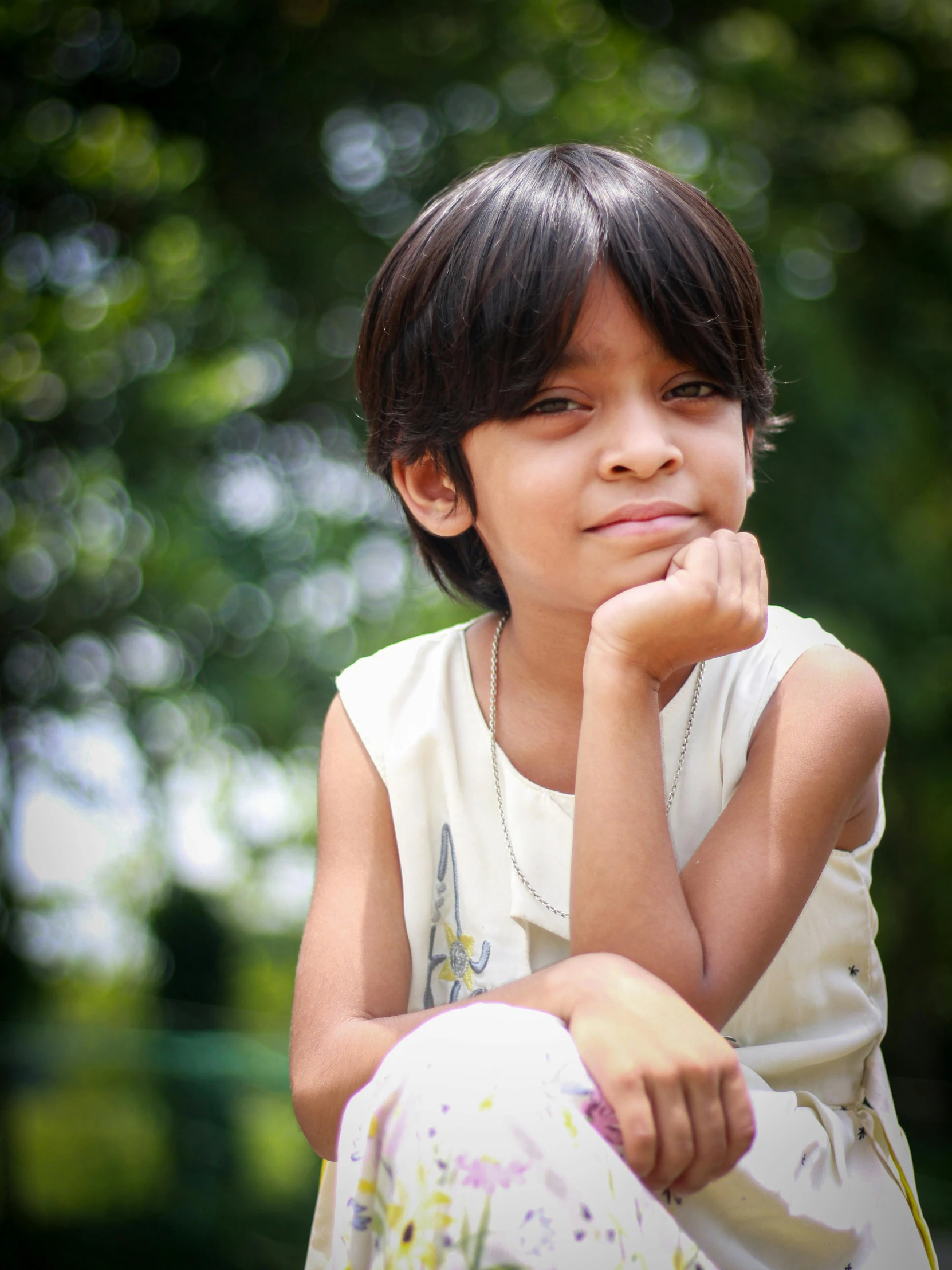 a girl poses for a po with her arm resting on her chin