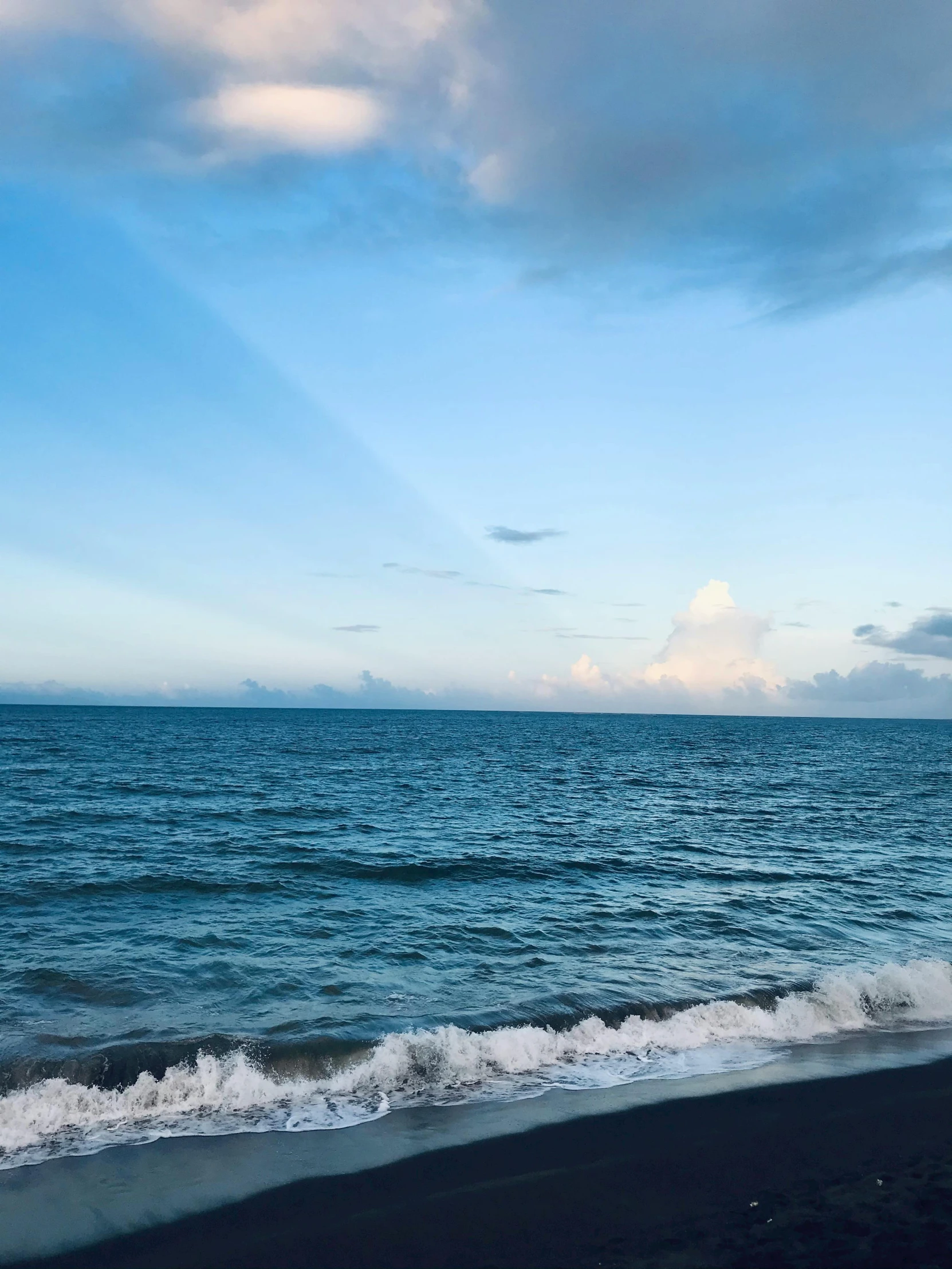 an ocean scene with the sky and clouds