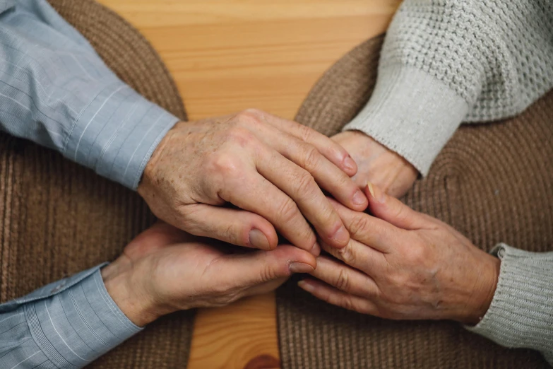 two people are holding their hands together on the table