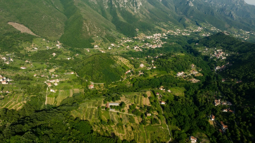 a small village on the hillside is surrounded by mountains