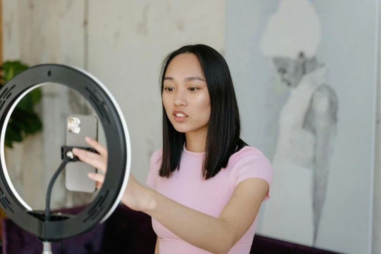 a woman looking at her cellphone through a round mirror