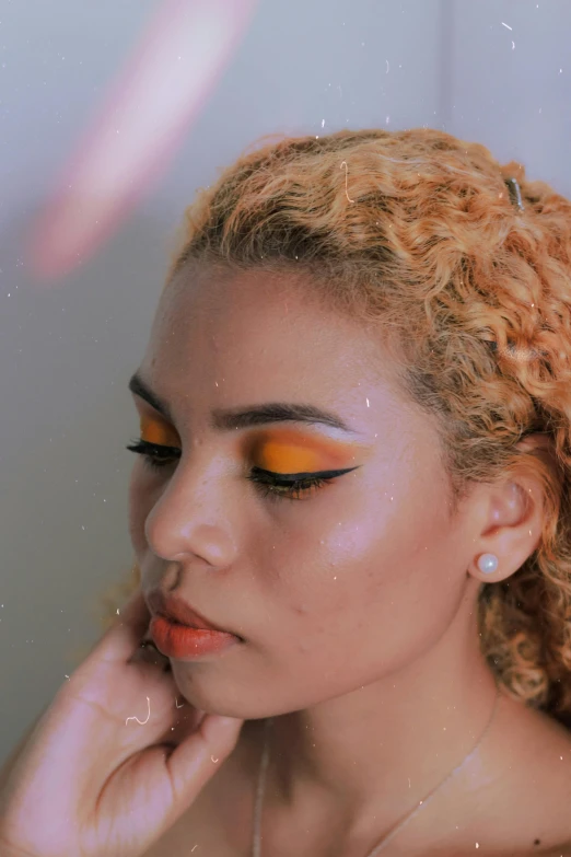 a woman with curly hair has her face painted orange