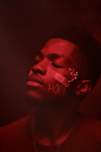 a man in the middle of a red light with the word hope painted on his face