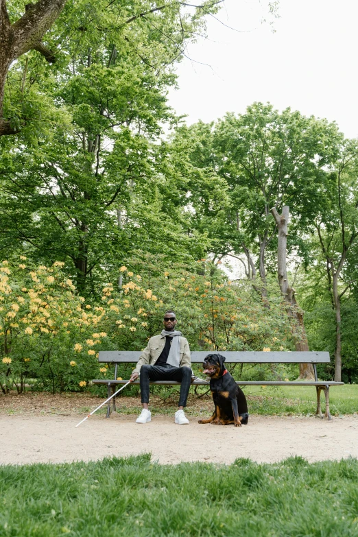 a man sitting on a bench with a dog on a leash